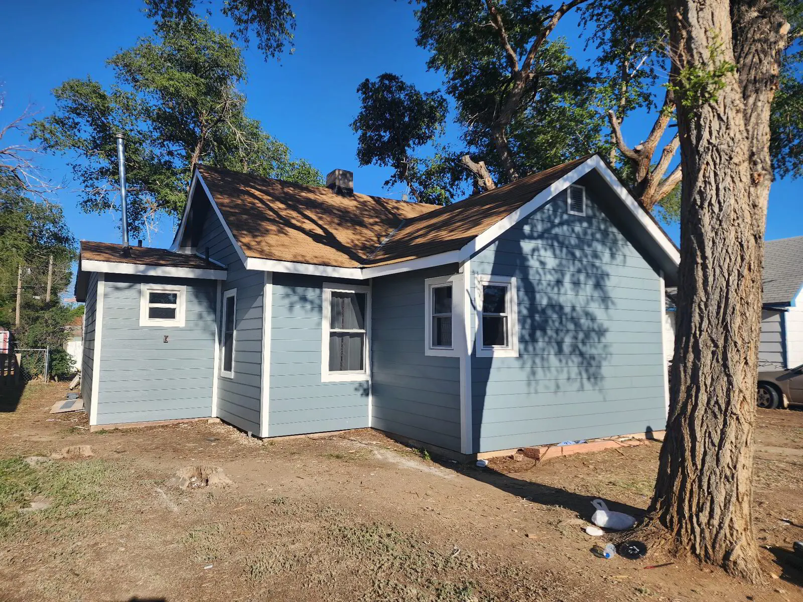 Cottage exterior — Siding, trim, and fascia complete.